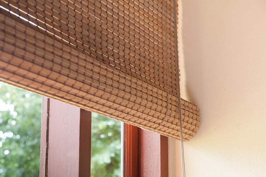 window with custom wooden roller shades at house